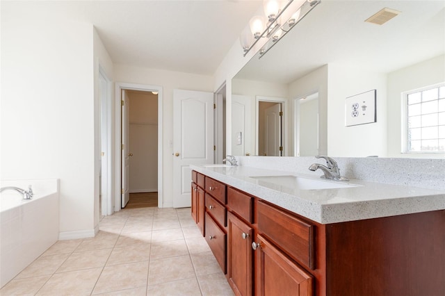 bathroom featuring a relaxing tiled tub, vanity, and tile patterned flooring