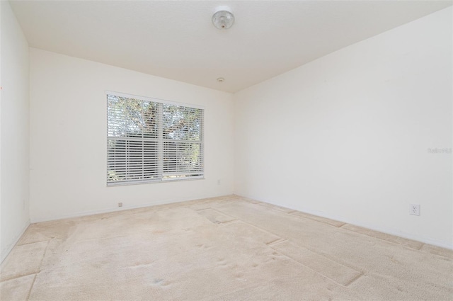 spare room featuring light carpet