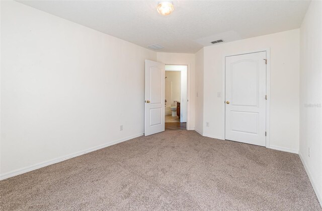 unfurnished bedroom featuring carpet flooring, baseboards, and visible vents