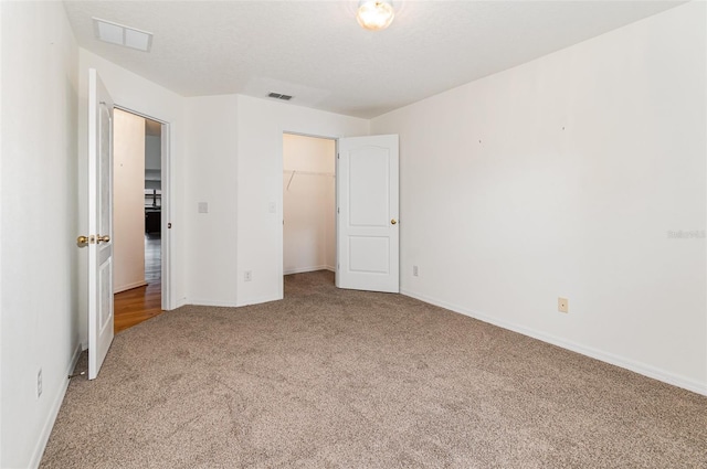 unfurnished bedroom featuring visible vents, carpet floors, and baseboards