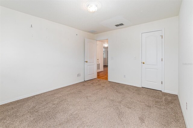 unfurnished bedroom featuring baseboards, visible vents, and carpet floors