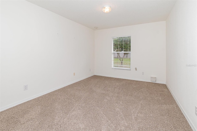 carpeted empty room featuring baseboards