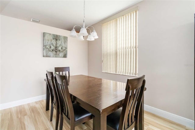 dining area featuring a chandelier and light wood-type flooring