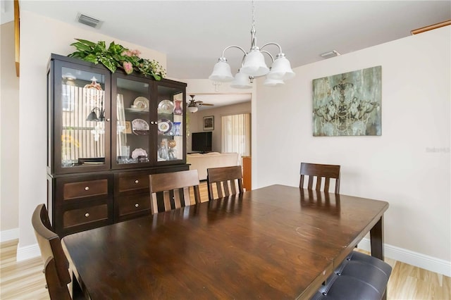 dining space featuring light hardwood / wood-style flooring and an inviting chandelier