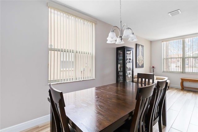 dining area featuring light wood-type flooring and a chandelier