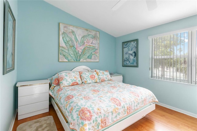 bedroom with hardwood / wood-style flooring, vaulted ceiling, and ceiling fan