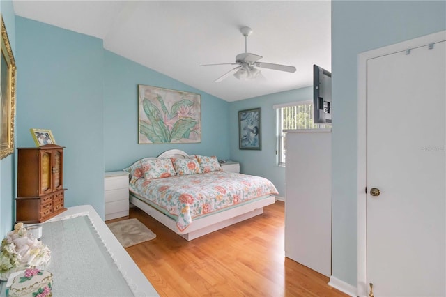 bedroom with ceiling fan, hardwood / wood-style floors, and lofted ceiling