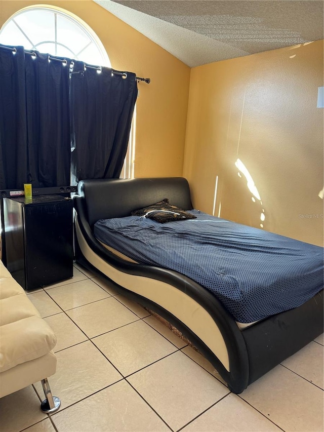 tiled bedroom featuring vaulted ceiling and a textured ceiling