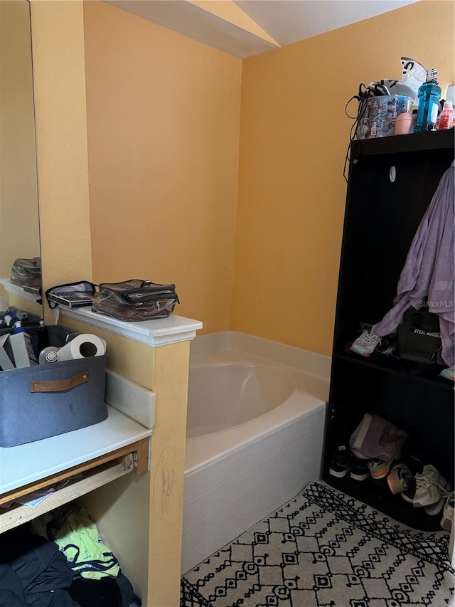 bathroom featuring tile patterned flooring and tiled tub