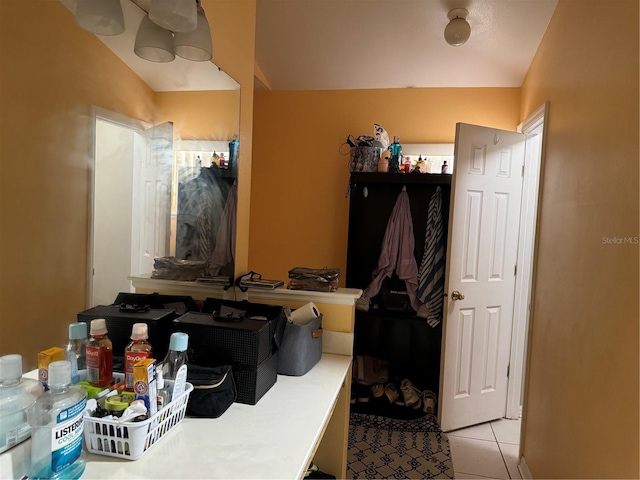 bathroom with lofted ceiling and tile patterned floors