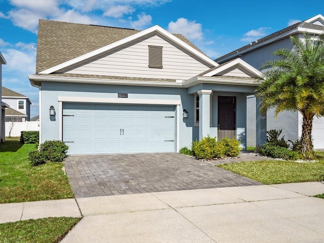 view of front of property featuring a garage and a front lawn