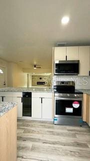 kitchen featuring white cabinetry, appliances with stainless steel finishes, and light wood-style flooring