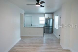 empty room with ceiling fan and light wood-style floors