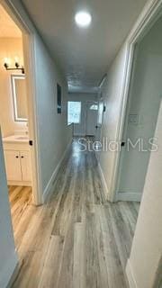 hallway featuring wood finished floors and baseboards