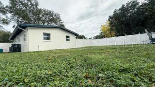 view of property exterior with a fenced backyard and a yard