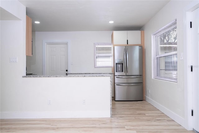 2002 Geigel Ave, Orlando, FL 32806 - kitchen with stainless steel refrigerator with ice dispenser, light wood-style flooring, a peninsula, baseboards, and light stone countertops
