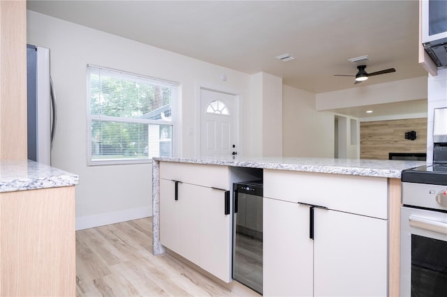 2002 Geigel Ave, Orlando, FL 32806 - kitchen featuring wine cooler, a ceiling fan, light stone countertops, and light wood-style floors