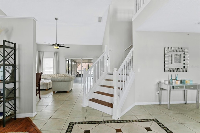 stairs featuring ceiling fan, tile patterned floors, and high vaulted ceiling