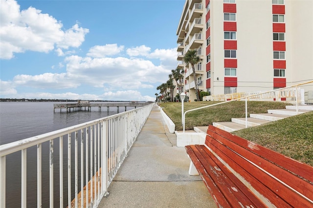 surrounding community with a boat dock and a water view