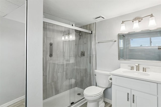 bathroom featuring vanity, wood-type flooring, walk in shower, and toilet