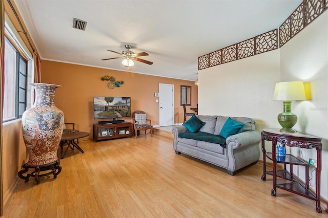 living room with light hardwood / wood-style flooring, ceiling fan, and ornamental molding