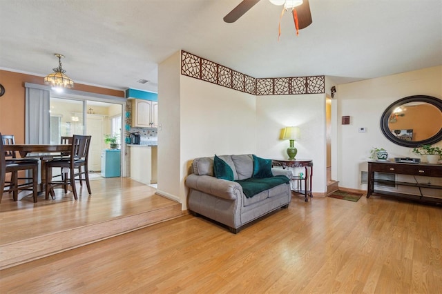 living room featuring ceiling fan, light hardwood / wood-style flooring, and crown molding