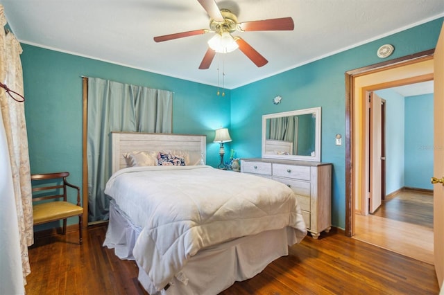 bedroom with ceiling fan, crown molding, and dark hardwood / wood-style flooring