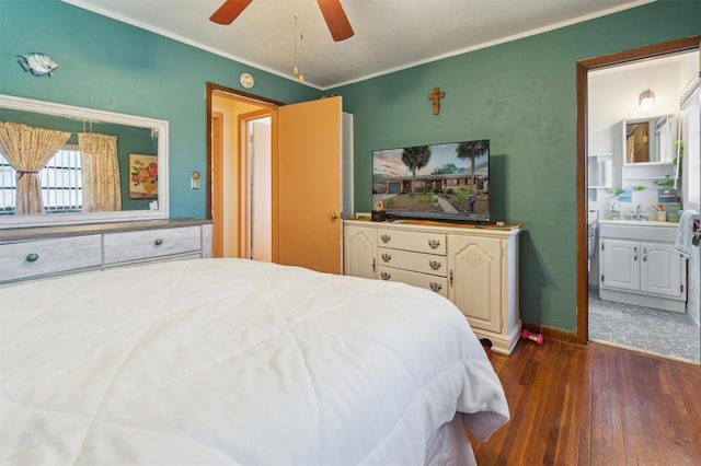 bedroom with crown molding, ceiling fan, sink, dark wood-type flooring, and ensuite bath