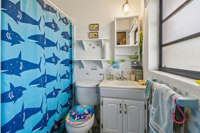 bathroom with toilet, vanity, and a shower with curtain