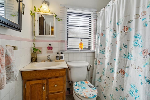 bathroom featuring tile walls, toilet, vanity, and walk in shower