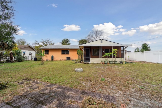 back of house featuring a lawn and a sunroom