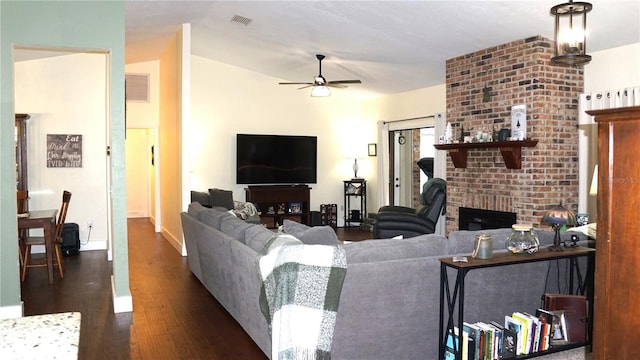 living room with ceiling fan, a fireplace, and dark hardwood / wood-style flooring