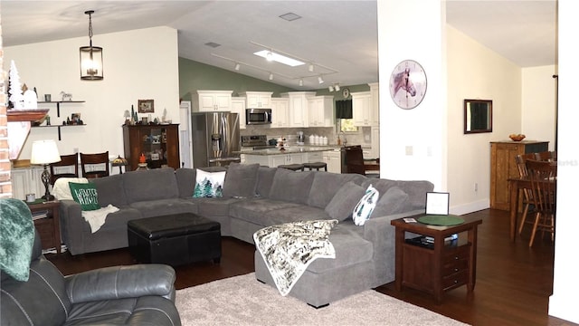 living room featuring vaulted ceiling, dark wood-type flooring, and track lighting