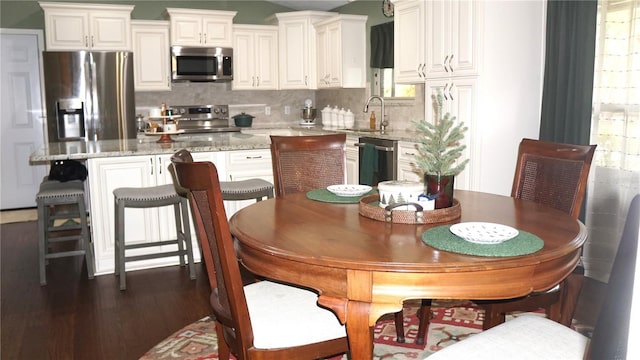 kitchen featuring light stone countertops, white cabinets, appliances with stainless steel finishes, and a center island