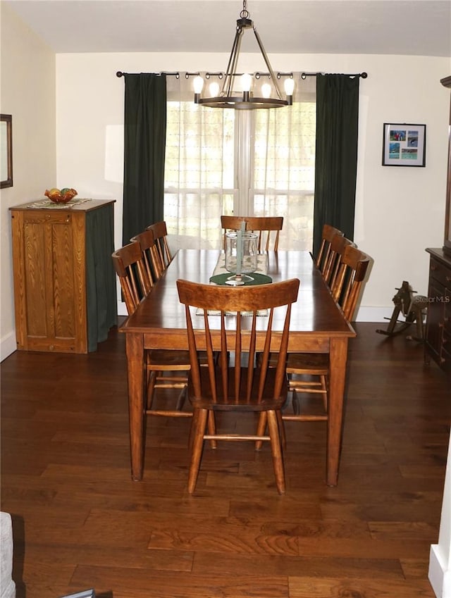 dining room with dark wood-type flooring and a chandelier