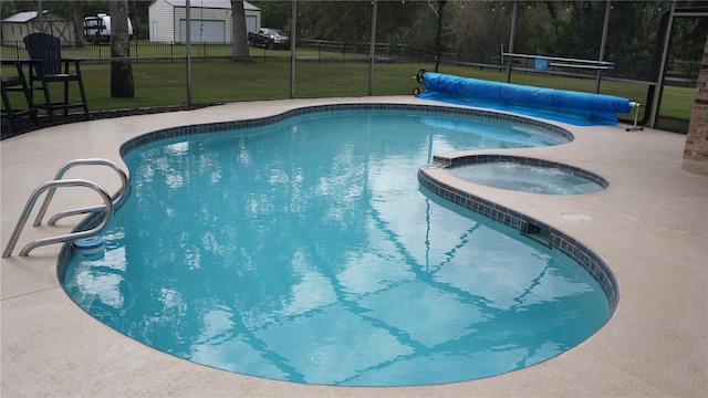 view of pool featuring an in ground hot tub, a lanai, a yard, and a patio area