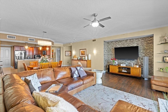 living room with dark hardwood / wood-style flooring, ceiling fan, crown molding, and a textured ceiling