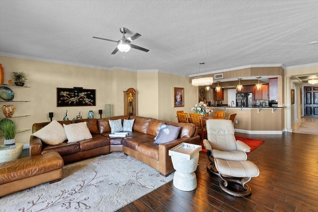 living room with hardwood / wood-style floors, ornamental molding, a textured ceiling, and ceiling fan