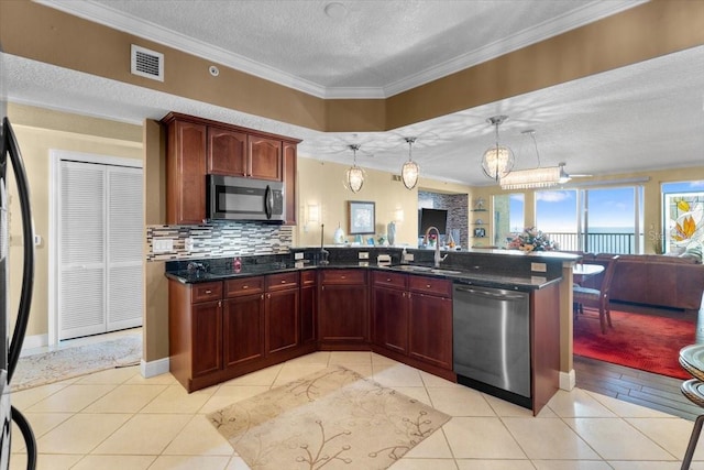 kitchen featuring sink, light tile patterned floors, appliances with stainless steel finishes, hanging light fixtures, and a textured ceiling