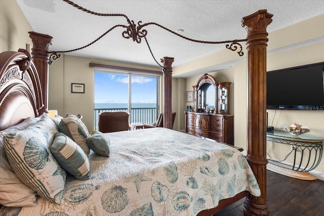 bedroom with wood-type flooring, access to exterior, and a textured ceiling