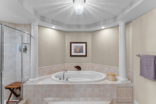 bathroom with independent shower and bath, decorative columns, and a textured ceiling