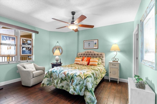 bedroom with multiple windows, dark hardwood / wood-style floors, a textured ceiling, and ceiling fan