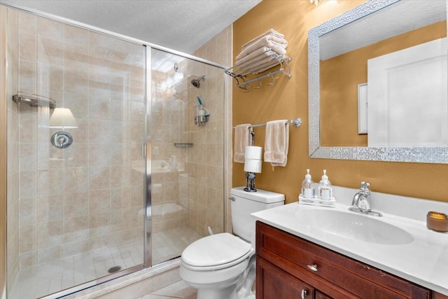 bathroom with vanity, a shower with shower door, toilet, and a textured ceiling