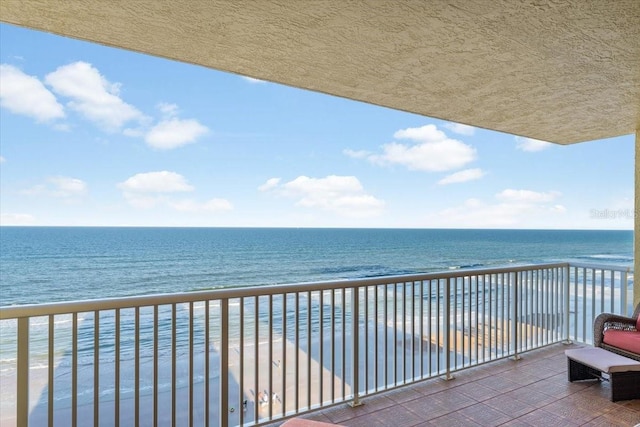 balcony with a water view and a beach view