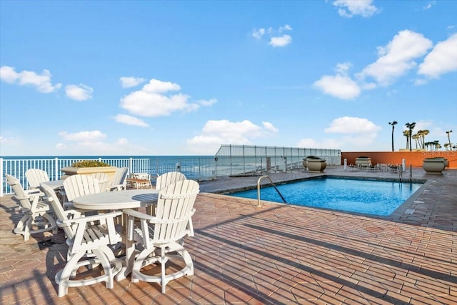 view of swimming pool with a patio and a water view