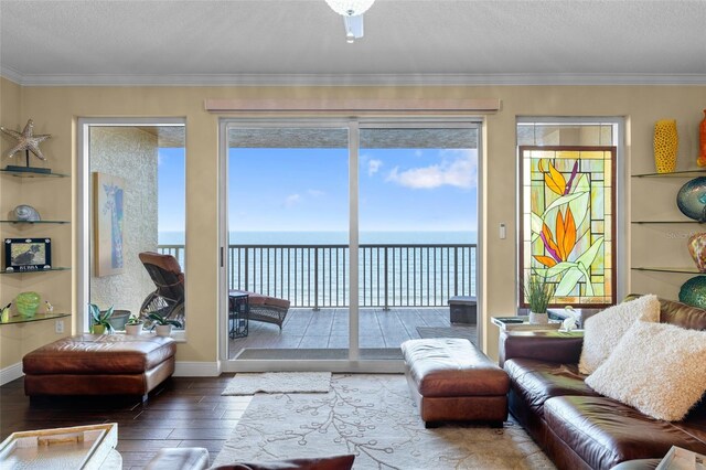 2901 S Atlantic Ave Unit 702, Daytona Beach, FL 32118 - living area featuring wood-type flooring, a water view, a textured ceiling, and crown molding