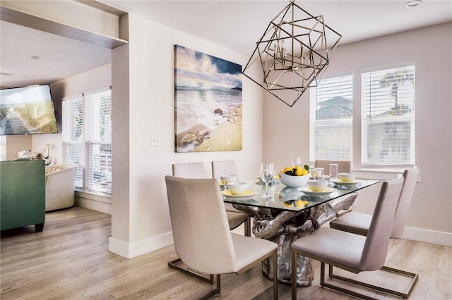 dining space with a notable chandelier and light hardwood / wood-style flooring