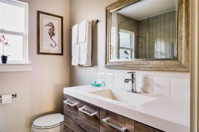 bathroom with vanity, plenty of natural light, backsplash, and toilet