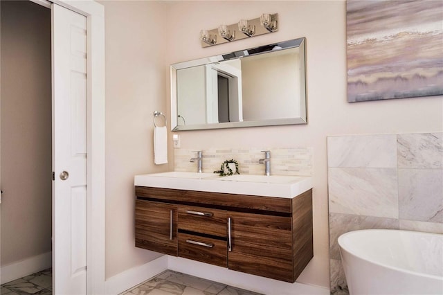 bathroom featuring vanity, decorative backsplash, and a tub