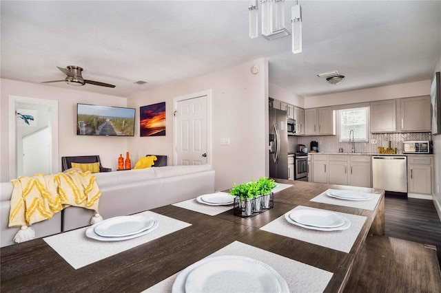 dining space with ceiling fan, dark hardwood / wood-style flooring, and sink